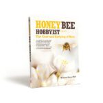 Book cover of 'Honeybee Hobbyist' by Norman Gary, PhD., featuring a close-up photograph of a bee flying above a white flower.