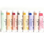 Lineup of Bee Haven Lip Balms tubes featuring the eight different flavors available.