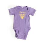 Lavender baby onesie with vibrant yellow text that reads 'Queen,' followed by a large bee illustration.