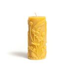 Beeswax candle with an intricate fern and curly tendrils design.
