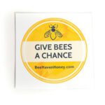 Circular yellow sticker with a navy blue bee graphic and text reading "Give Bees a Chance".